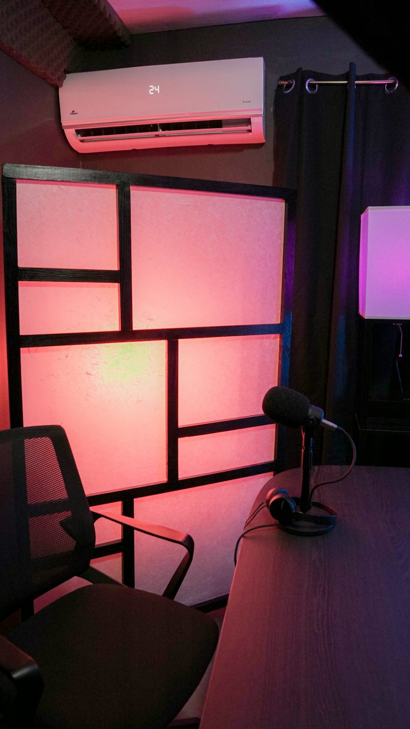 Microphone and headphones on a desk in a recording studio.